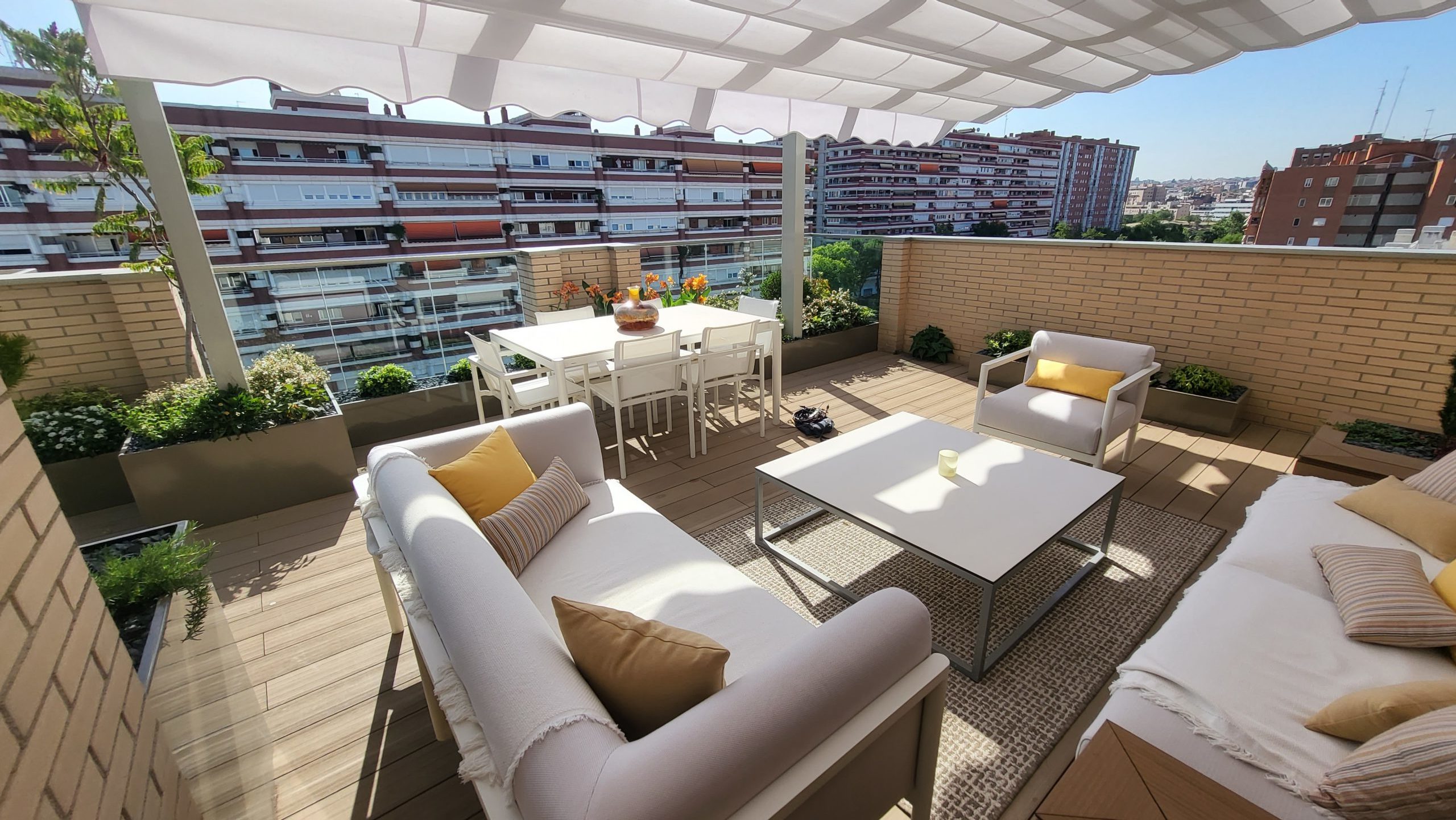 terraza con muebles para exterior y jardineras metálicas color beis